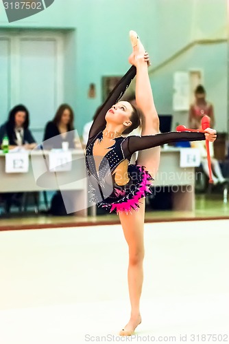 Image of Young girl shows exercise with maces to judges