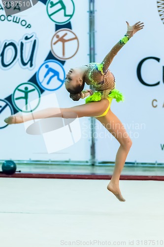 Image of Young beautiful girl shows exercise with maces