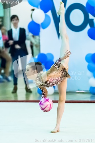 Image of Young pretty girl shows exercise with ball