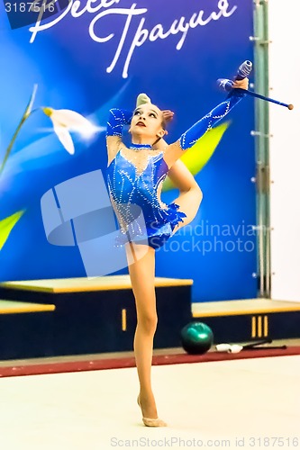 Image of Young attractive girl shows exercise with maces