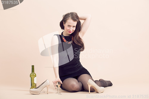 Image of beautiful young brunette woman holding a glass of white wine