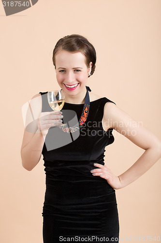 Image of beautiful young brunette woman holding a glass of white wine