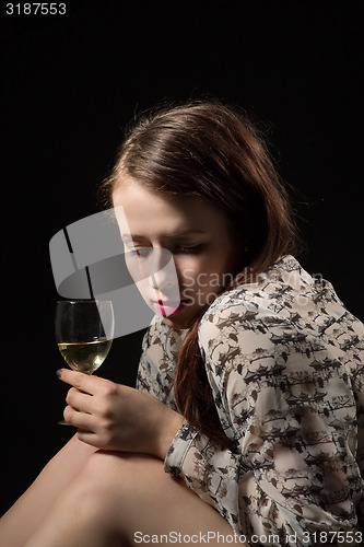 Image of beautiful young brunette woman holding a glass of white wine