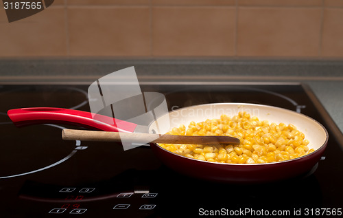 Image of cooking sweet conn with wooden spoon