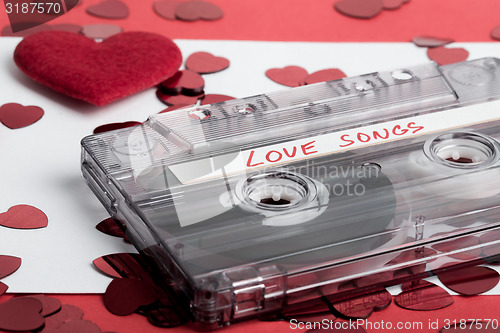 Image of Audio cassette tape on red backgound with fabric heart