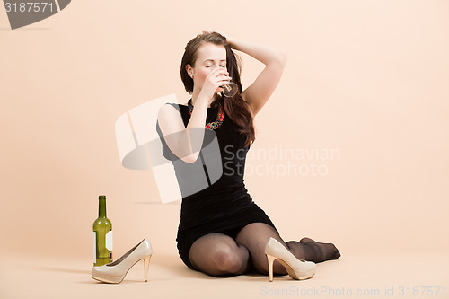 Image of beautiful young brunette woman holding a glass of white wine