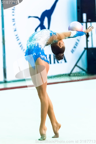 Image of Young attractive girl shows exercise with ball