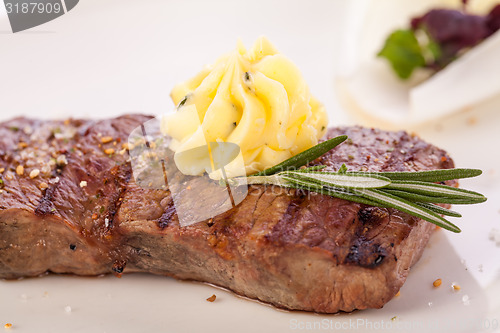 Image of Grilled beef steak topped with butter and rosemary