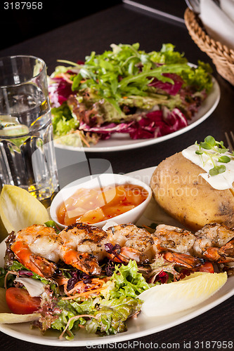 Image of Grilled prawns with endive salad and jacket potato