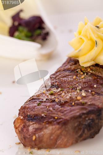 Image of Grilled beef steak topped with butter and rosemary