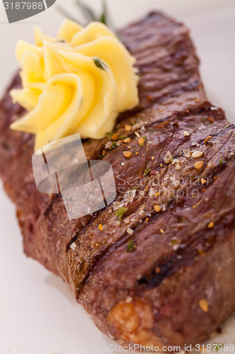 Image of Grilled beef steak topped with butter and rosemary