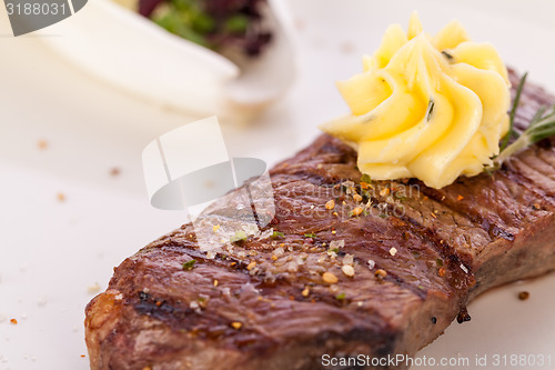 Image of Grilled beef steak topped with butter and rosemary