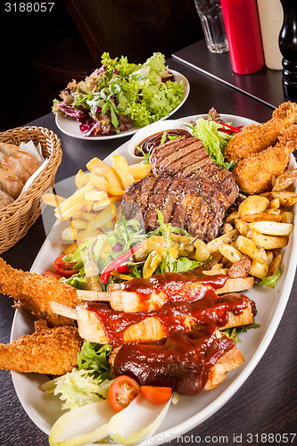 Image of Platter of mixed meats, salad and French fries