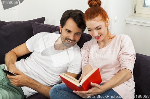 Image of Couple Resting on the Sofa at the Living Room