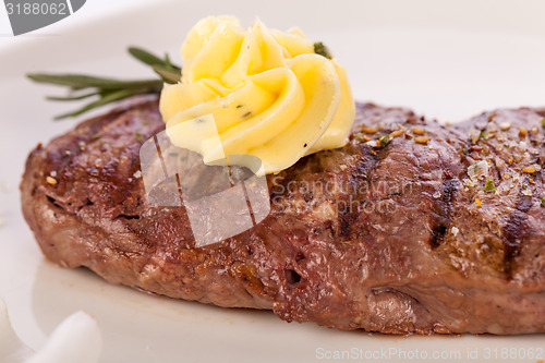 Image of Grilled beef steak topped with butter and rosemary