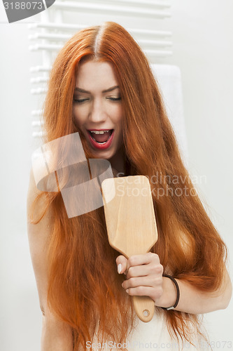 Image of Woman Brushing her Hair In Front a Mirror