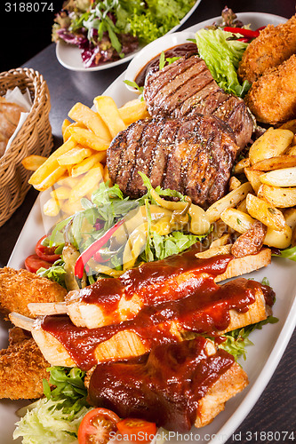 Image of Platter of mixed meats, salad and French fries