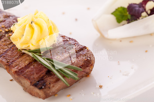 Image of Grilled beef steak topped with butter and rosemary