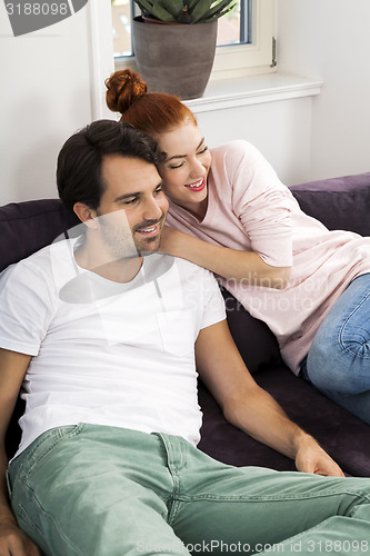 Image of Happy Young Sweet Couple Sitting at the Couch