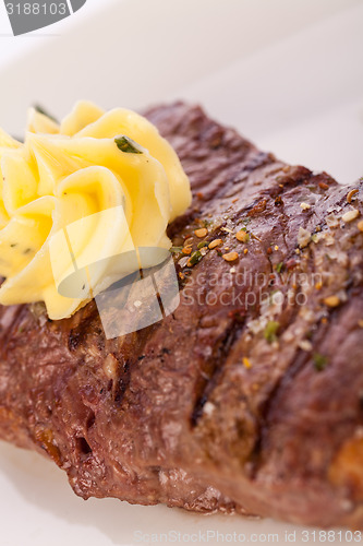 Image of Grilled beef steak topped with butter and rosemary