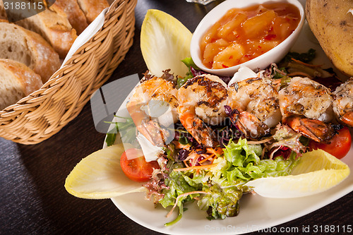 Image of Grilled prawns with endive salad and jacket potato