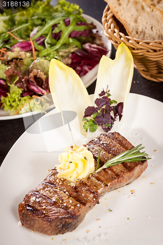 Image of Grilled beef steak topped with butter and rosemary