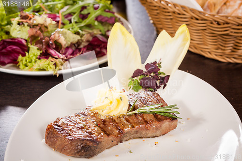 Image of Grilled beef steak topped with butter and rosemary