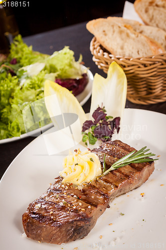 Image of Grilled beef steak topped with butter and rosemary