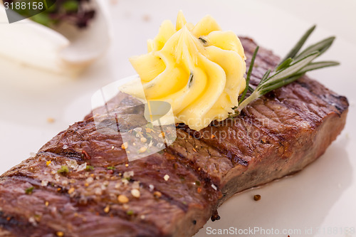 Image of Grilled beef steak topped with butter and rosemary