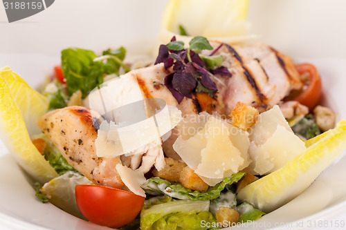 Image of tasty fresh caesar salad with grilled chicken and parmesan