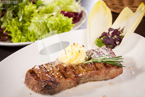 Image of Grilled beef steak topped with butter and rosemary