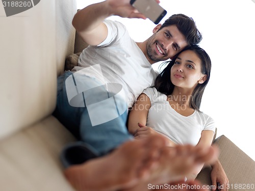 Image of young couple making selfie together at home