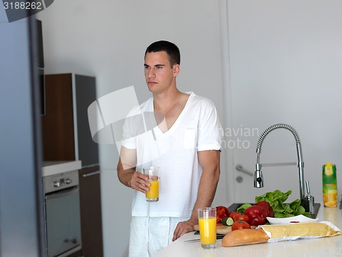 Image of man cooking at home preparing salad in kitchen