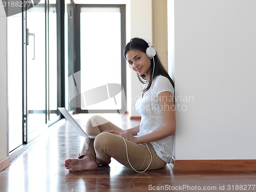 Image of relaxed young woman at home working on laptop computer