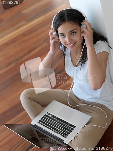 Image of relaxed young woman at home working on laptop computer