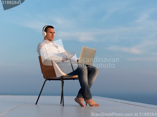 Image of relaxed young man at home on balcony