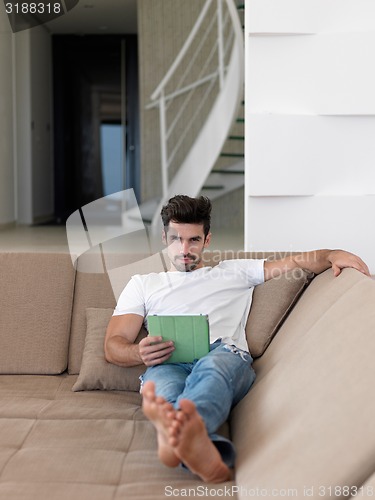 Image of man using tablet computer from home