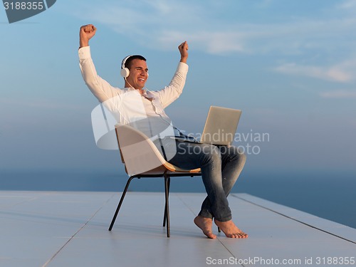 Image of relaxed young man at home on balcony