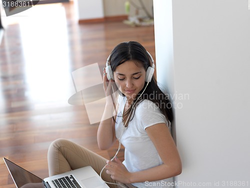 Image of relaxed young woman at home working on laptop computer