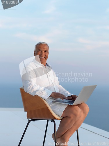 Image of relaxed senior man on balcony