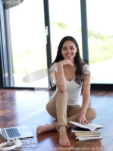 Image of relaxed young woman at home working on laptop computer