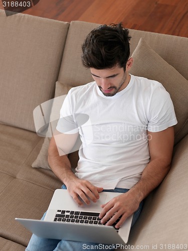 Image of Man Relaxing On Sofa With Laptop