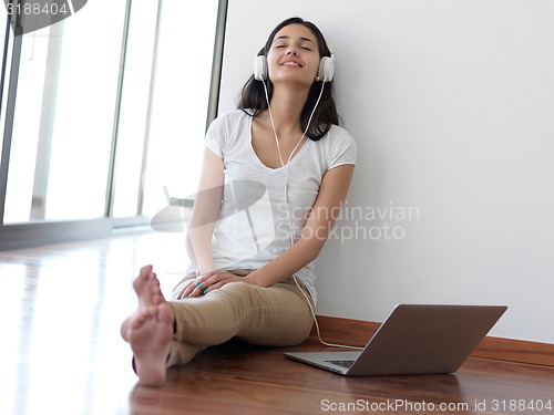 Image of relaxed young woman at home working on laptop computer