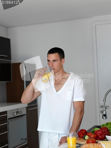 Image of man cooking at home preparing salad in kitchen