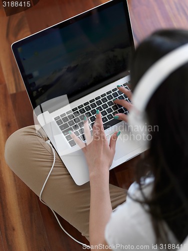 Image of relaxed young woman at home working on laptop computer