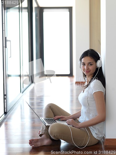Image of relaxed young woman at home working on laptop computer