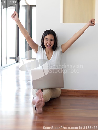 Image of relaxed young woman at home working on laptop computer