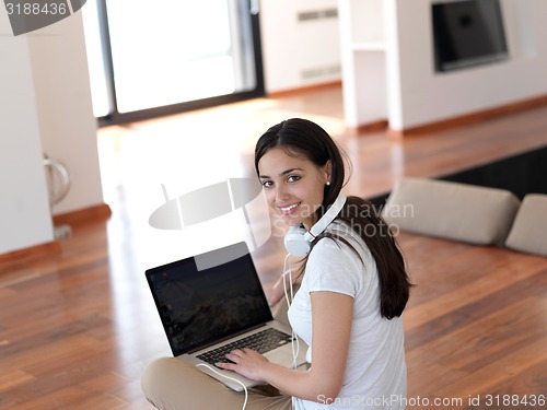 Image of relaxed young woman at home working on laptop computer