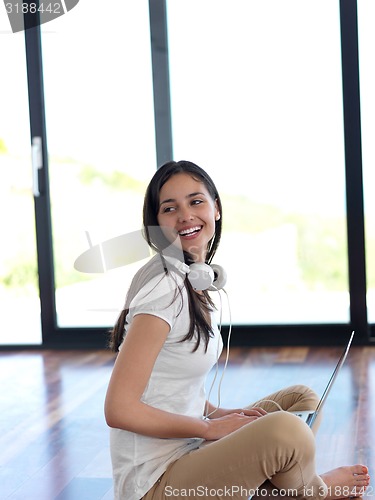 Image of relaxed young woman at home working on laptop computer