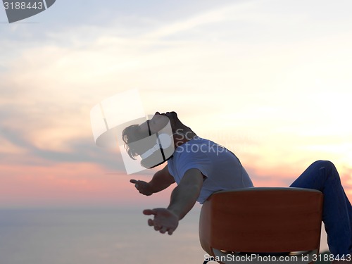 Image of relaxed young man at home on balcony